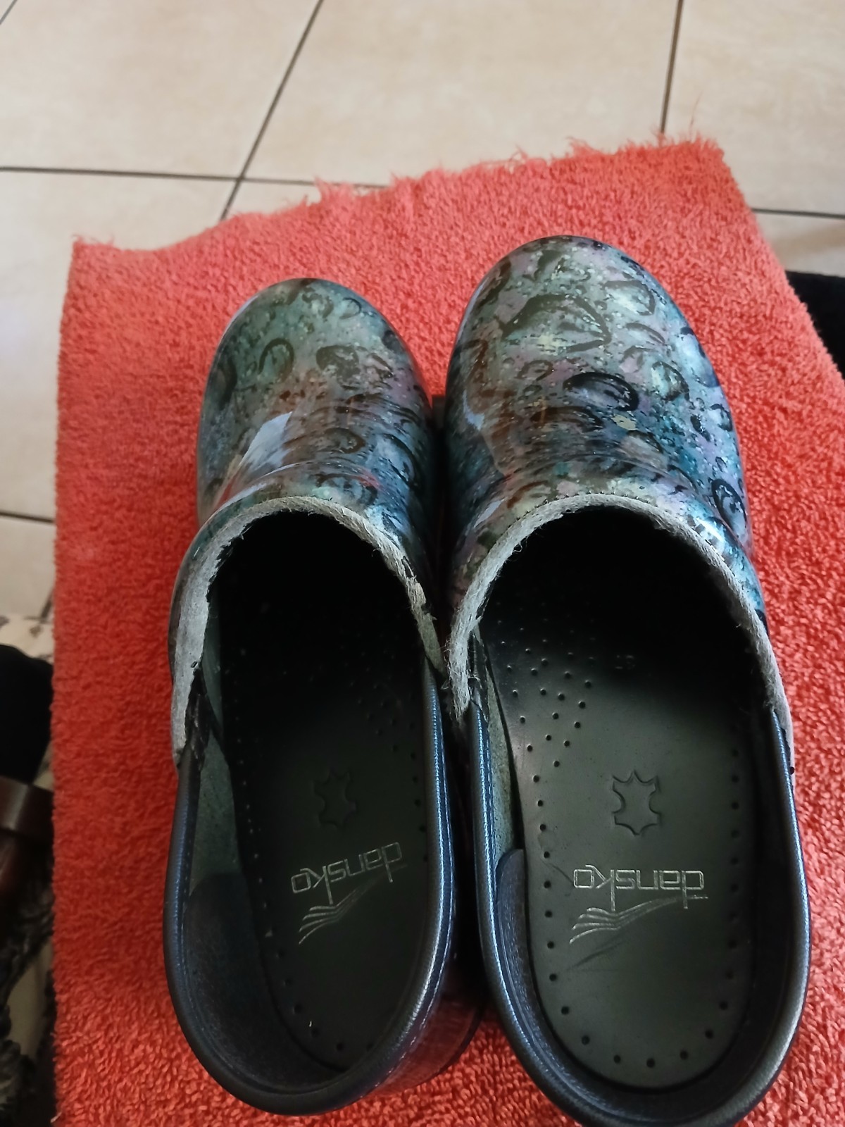 Dansko Professional clogs featuring a distinct floral patent leather finish….