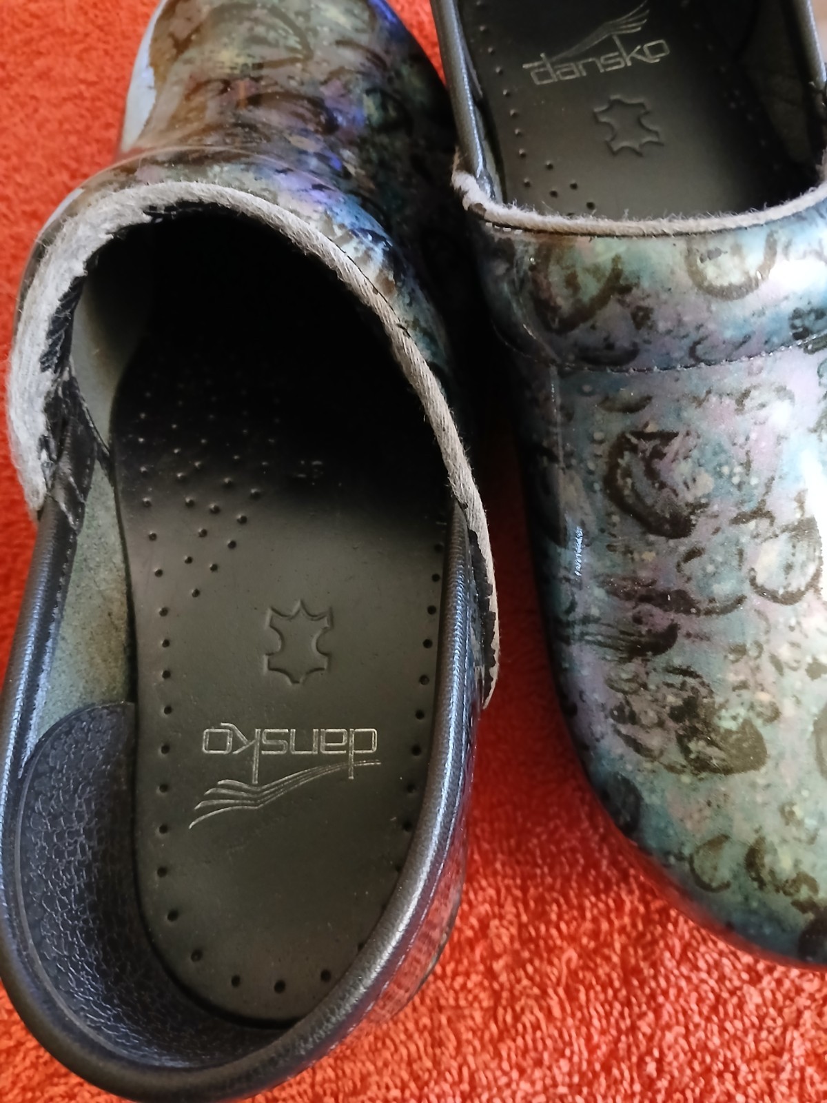 Dansko Professional clogs featuring a distinct floral patent leather finish….