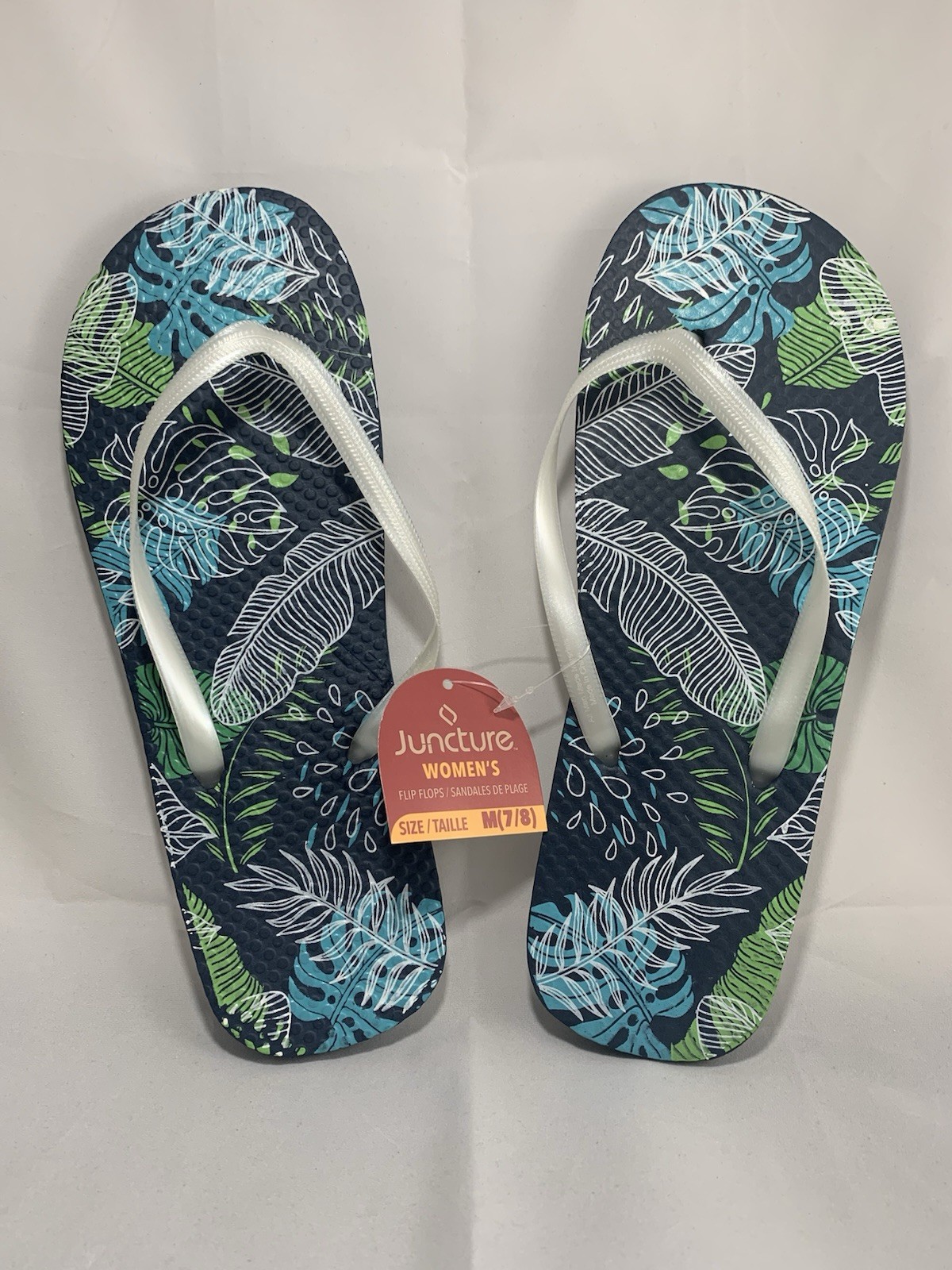 Juncture Women’s Flip Flops; Size Medium (7/8 ) Background color is dark blue.
