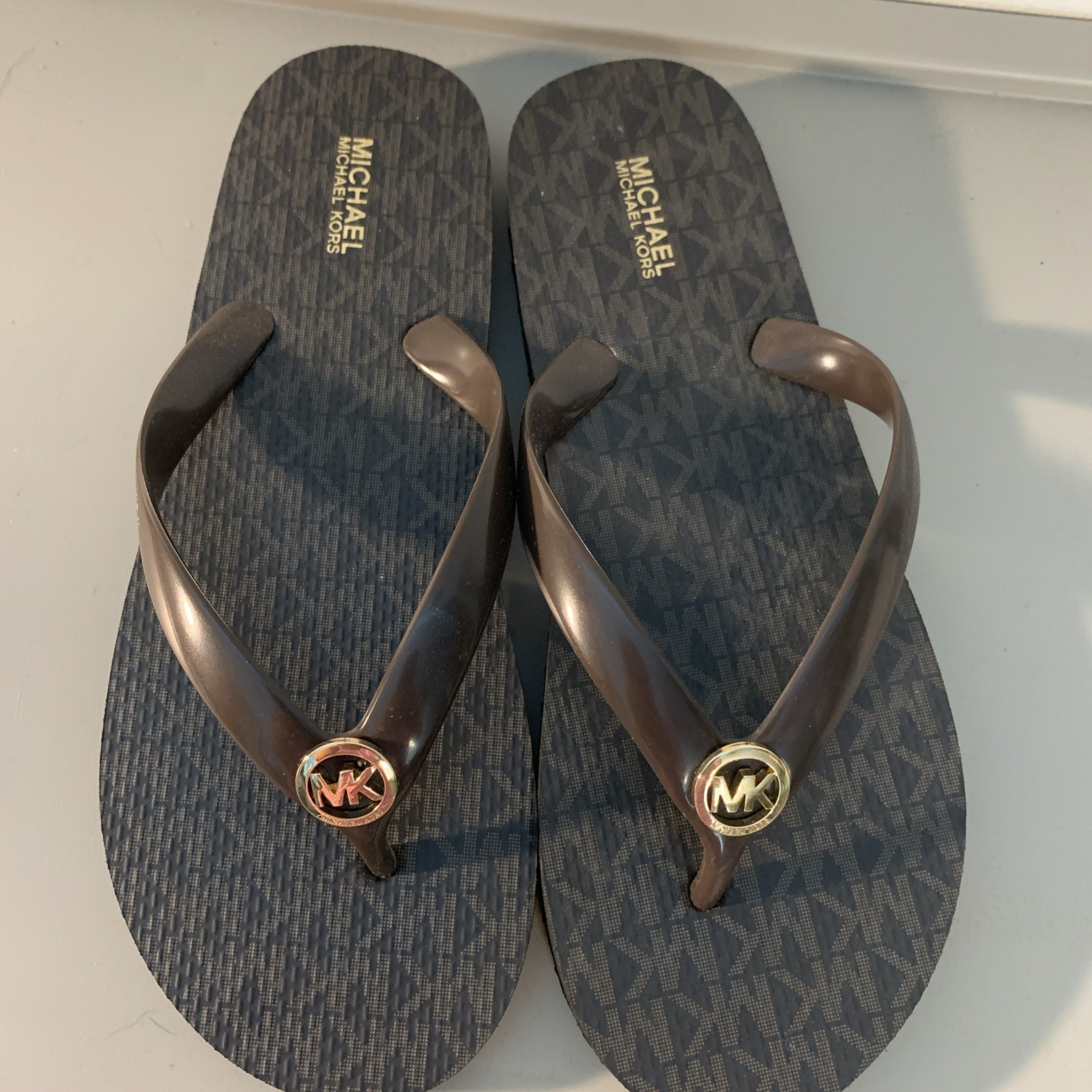 New MICHAEL KORS Women’s 9 Brown / Gold Metal MK Charm Logo Flip Flops MSRP $75