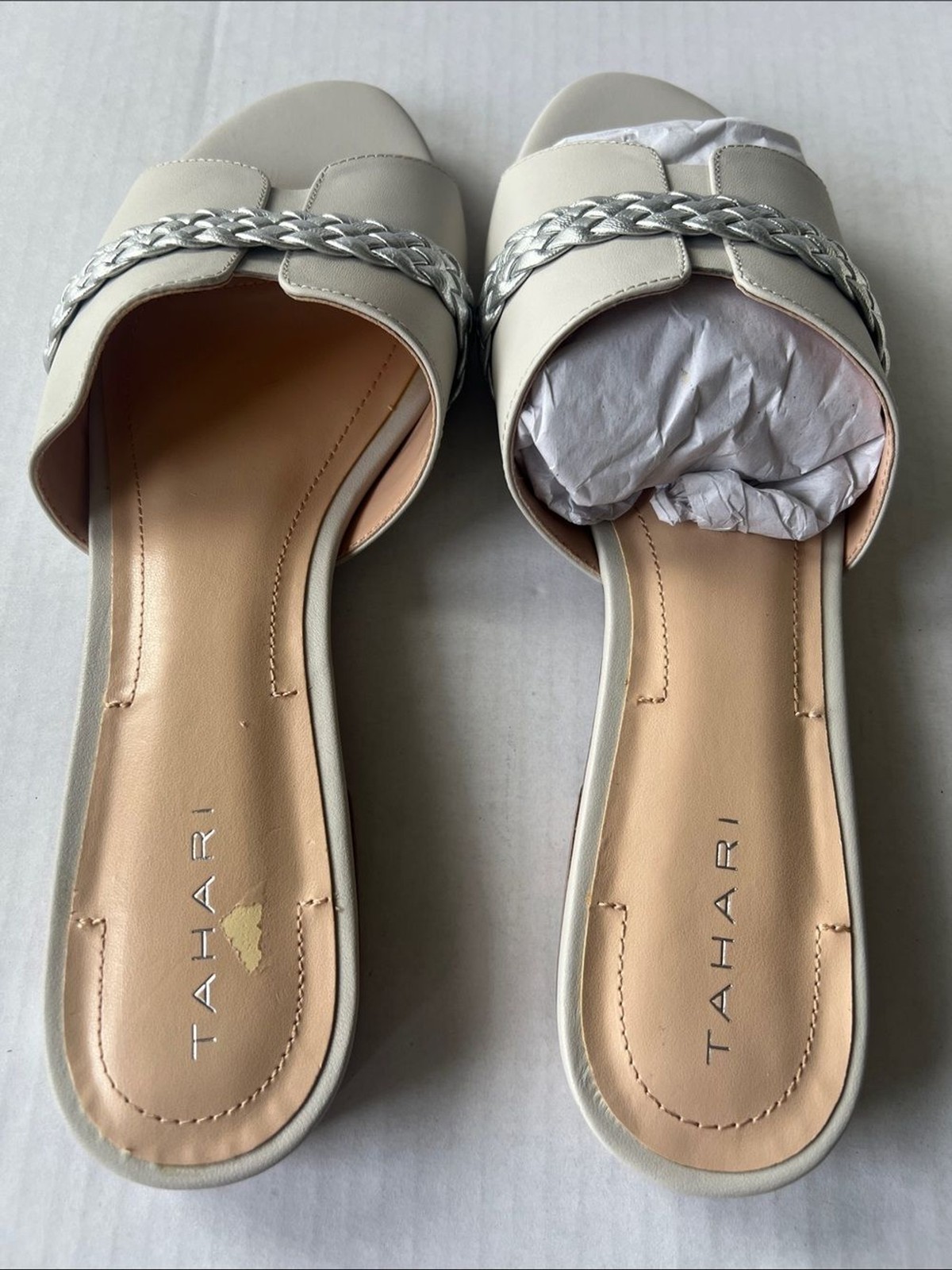 Tahari «Amorie» slide sandals featuring white leather upper silver braided strap