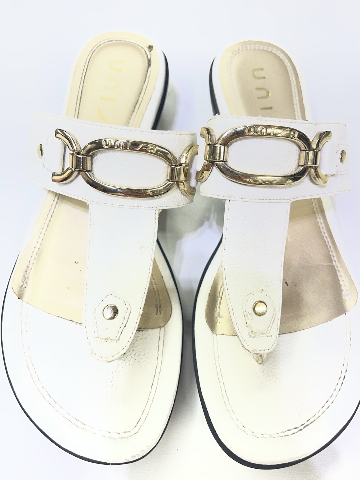 Unisa brand white mules featuring a gold-tone metal detail. Sz 9w