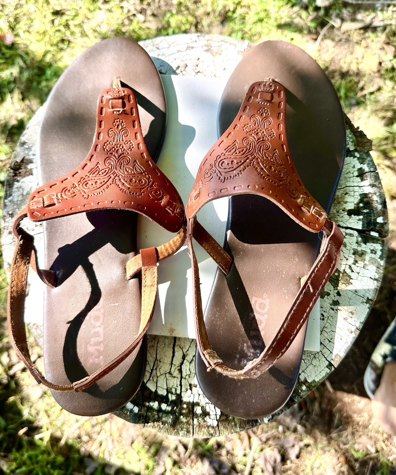 brown Mudd sandals feature intricate embossed paisley designs on the front strap