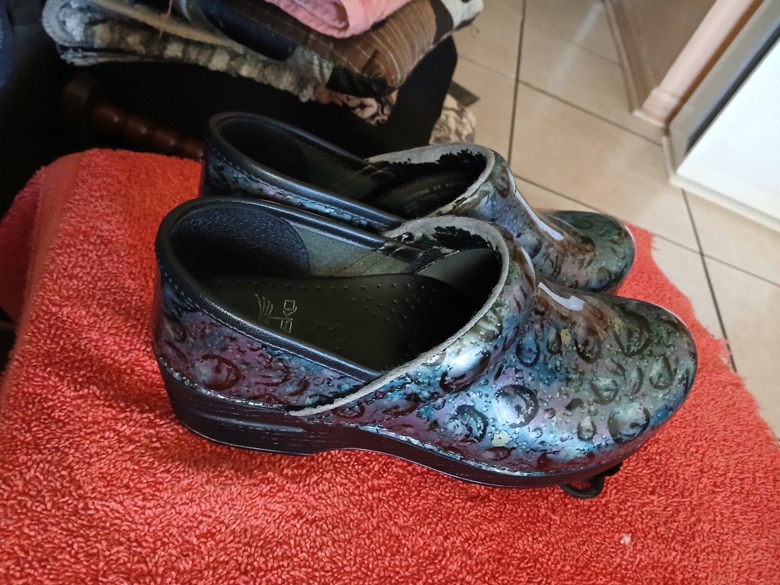 Dansko Professional clogs featuring a distinct floral patent leather finish….