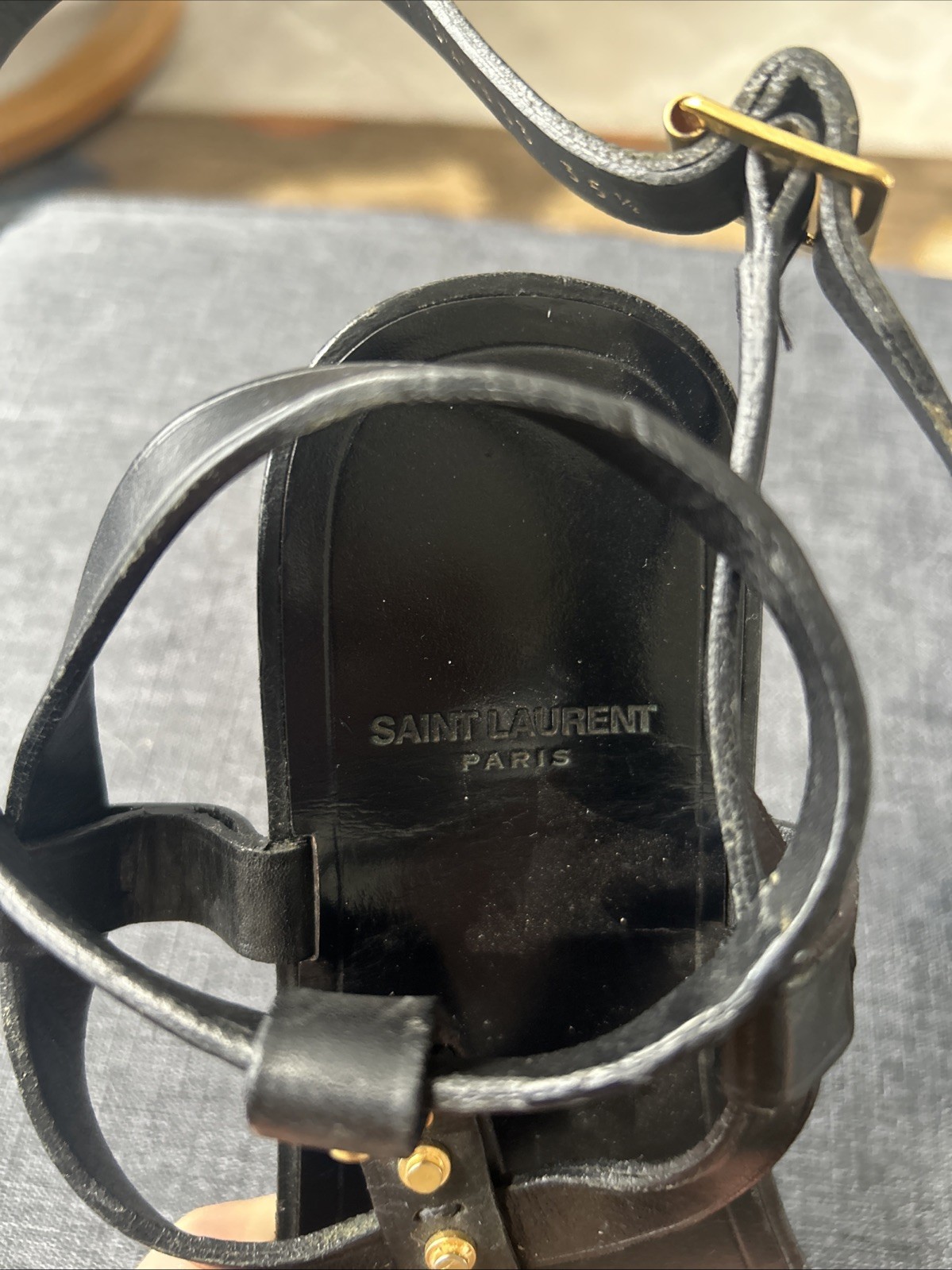 Black leather Saint Laurent sandals feature gold-tone studded accents. Size 35.5