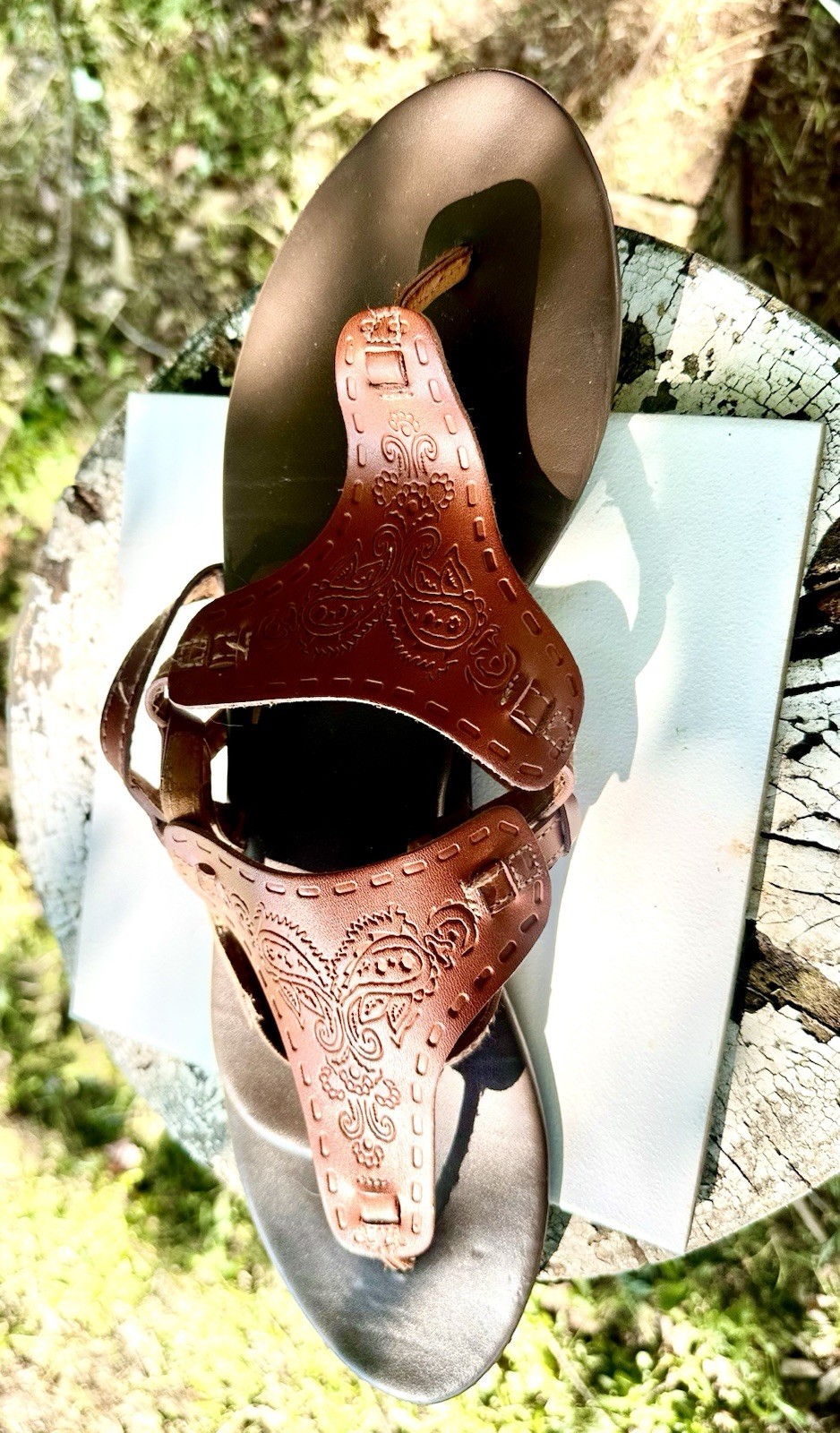 brown Mudd sandals feature intricate embossed paisley designs on the front strap