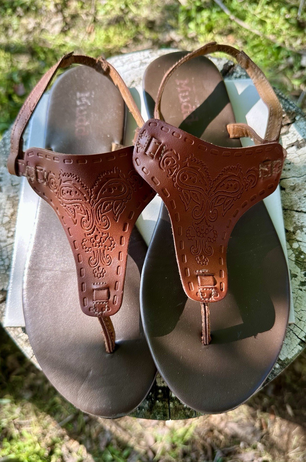 brown Mudd sandals feature intricate embossed paisley designs on the front strap