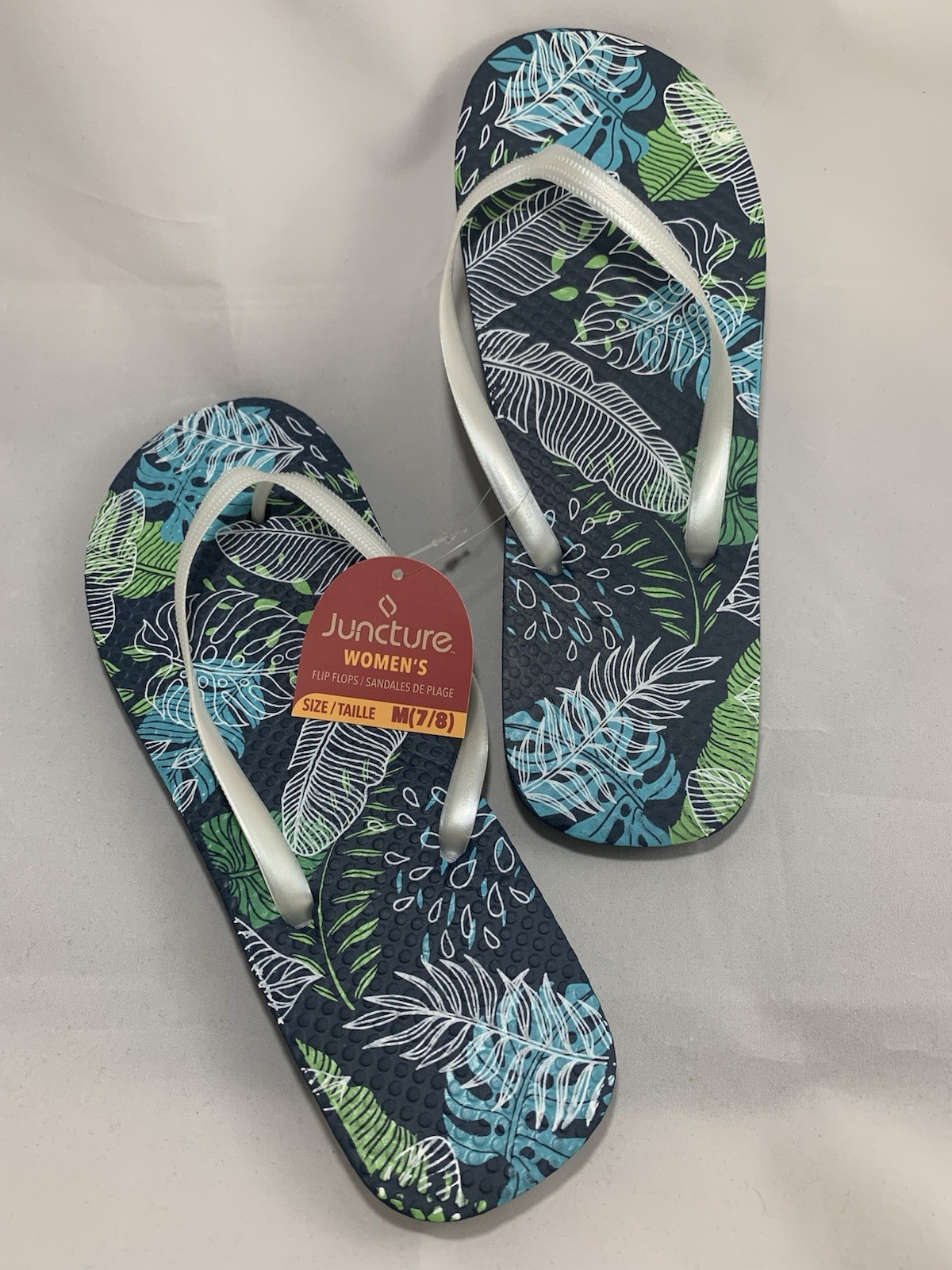Juncture Women’s Flip Flops; Size Medium (7/8 ) Background color is dark blue.