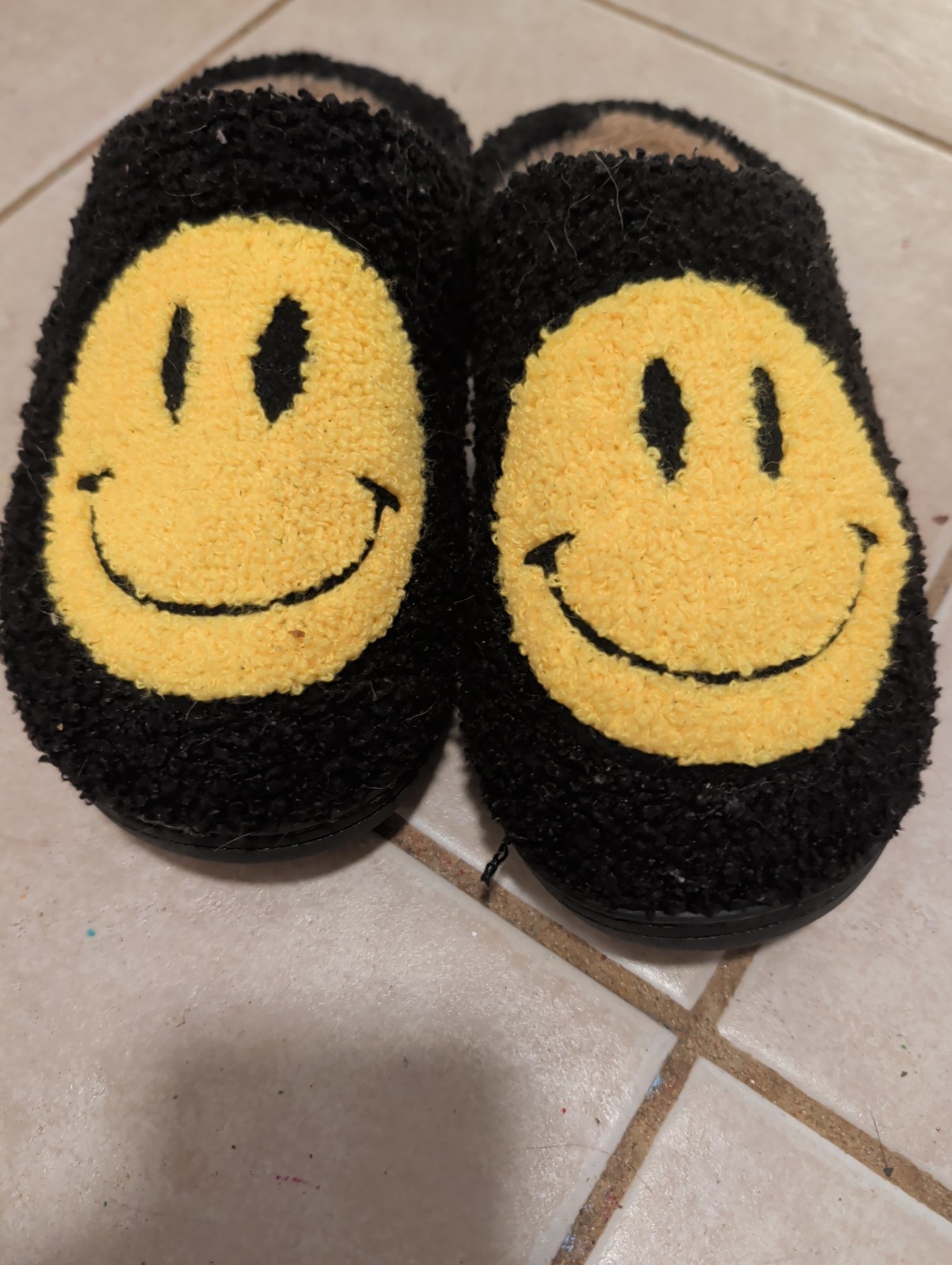 women’s well worn slippers with happy face